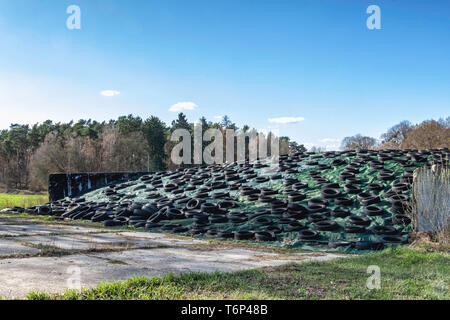 Silage mound with cover held in place by old tyres.The fermented, green forage fodder is used to feed cattle & sheep Stock Photo