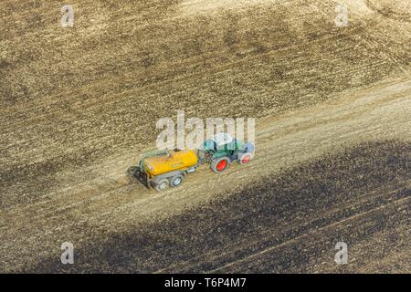 Aerial view, liquid manure is sprayed as fertilizer with tractor and tank trailer on agricultural fields, Enkdorf, Meschede, Federal State North Stock Photo