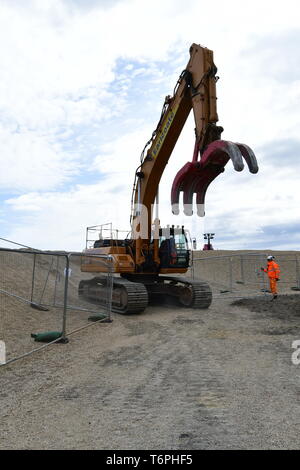 West Bay, Dorset, UK. 2nd May 2019. A large coastal defence is underway at West Bay in Dorset. Large blocks are delivered by boats and off loaded into the sea front by bucket loads. The stones come from Scotland where its picked up by large mechanical clasps and driven up the pebble beach. The sea front is where the TV show Broadchurch was filmed.Picture Credit: Robert Timoney/Alamy Live Newss Stock Photo