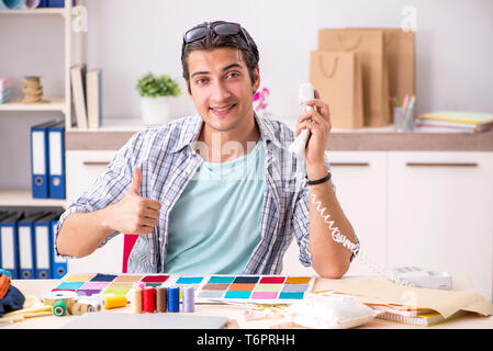 Young handsome tailor working in his workshop Stock Photo