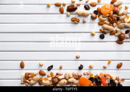 Various tasty nuts and dried fruits on wooden background Stock Photo