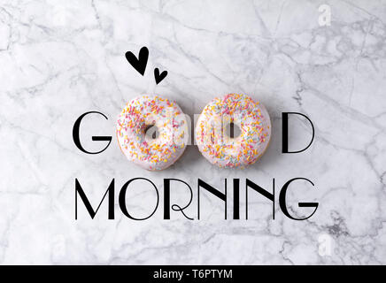 Two donuts and hearts. Good morning greeting written on marble gray background.  Stock Photo
