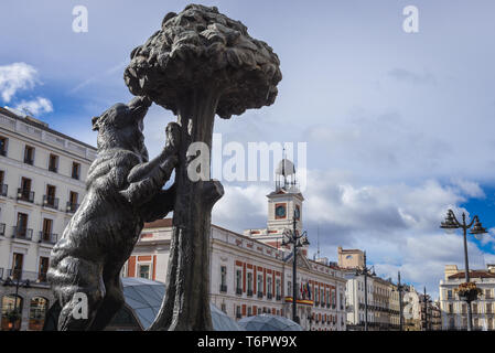 Statue of the Bear and the Strawberry Tree on a Puerta del Sol in Madrid, Spain, view with Royal House of Post Office building Stock Photo