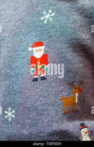 Knitted Santa claus, reindeer, snow and snowman on gray sweater. Stock Photo
