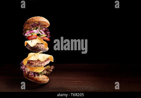 double cheeseburger on a wooden surface with a dark background and space for text Stock Photo