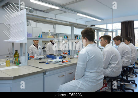 At a school chemistry lab. Pupils sitting in front of benches waiting for beginning chemistry lesson. Kiev, Ukraine. November 28, 2018 Stock Photo