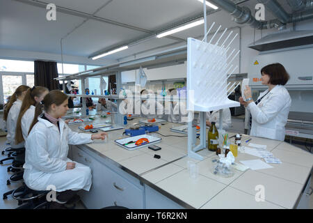 At a school chemistry lab. Pupils sitting in front of benches waiting for beginning chemistry lesson. Kiev, Ukraine. November 28, 2018 Stock Photo