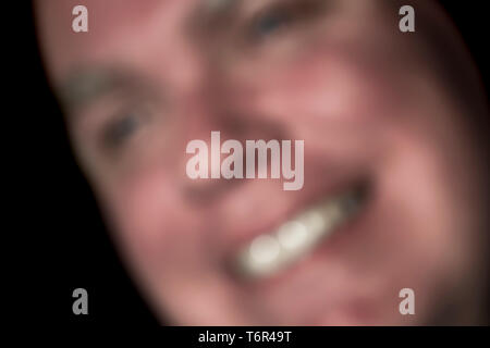 Blurred abstract image of a man with a happy, content, smiling face. Blurry image showing concept of happiness and contentment. Stock Photo