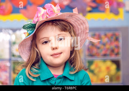 Cute little girl wearing pink wicker hat Stock Photo