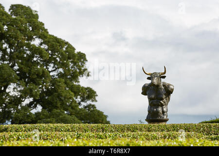 CAWDOR, NAIRN, SCOTLAND, UK - AUGUST 07, 2017: Labyrinth maze of Holly hedges in the Walled Garden of Cawdor Castle with bronze minotaur sculpture Stock Photo