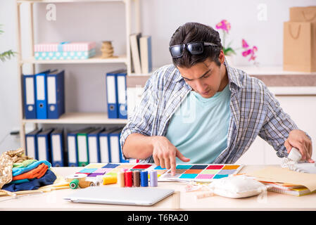 Young handsome tailor working in his workshop Stock Photo