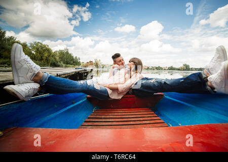Love is all that matters. Top view of beautiful young couple taking selfie using smart phone while lying in the boat. Love Story Stock Photo