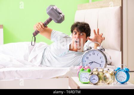 Young man having trouble waking up in early morning Stock Photo