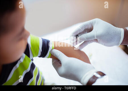 Close up of pediatrician wearing white gloves making injection Stock Photo
