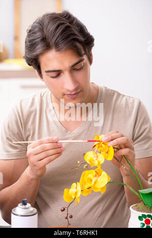 Young man decorating pottery in class Stock Photo