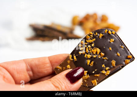 Hand holding chocolate with almonds on white background Stock Photo