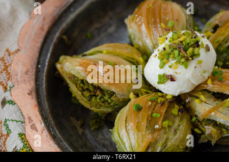 Mussel shaped special Turkish baklava with pistachio in the copper plate .Conceptual of Islamic Feasts. Stock Photo