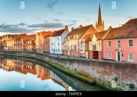 Pretty town houses overlooking the river Yare at Norwich in Norfolk with the cathedral spire in the background Stock Photo