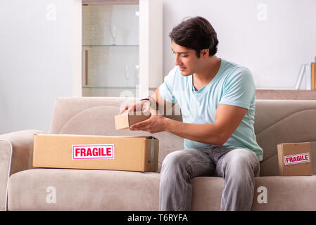 Man opening fragile parcel ordered from internet Stock Photo