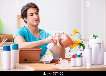 Young man decorating pottery in class Stock Photo