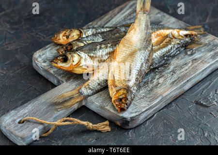 Dried fish on the serving board. Stock Photo