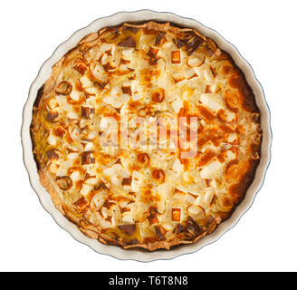 French style quiche with leek and feta or goats cheese in a baking dish. Vegetarian food. Top view isolated on white. Stock Photo