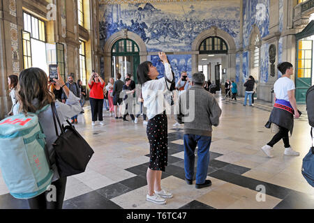 Tourist photographing azulejo tiles in the Central Hall of Sao Bento Station train rail railway stations in city of Porto Portugal Europe KATHY DEWITT Stock Photo
