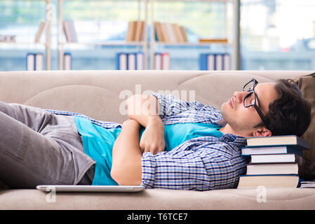 Tired student lying on the sofa Stock Photo