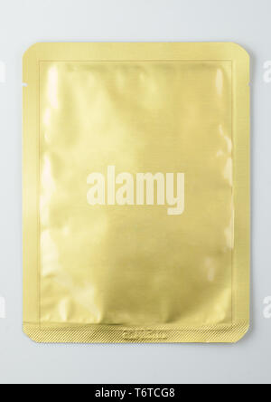 gold sealed cosmetic sachet, isolated on white background Stock Photo