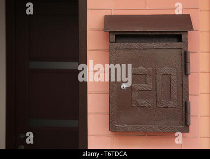 Brown mailbox on wall of building outdoors Stock Photo