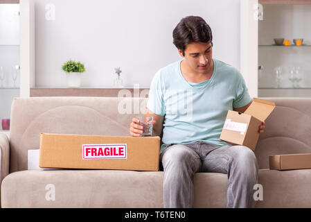 Man opening fragile parcel ordered from internet Stock Photo