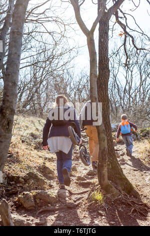 Active family walking on the mountain trail in the forest Stock Photo