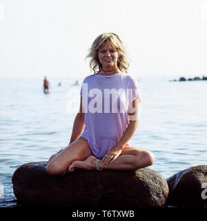 Die deutsche Schauspielerin Christiane Rücker posiert auf einem Stein im Meer, ca. 1970er. The German actress Christiane Rücker poses on a rock in the sea, ca. 1970s. Stock Photo