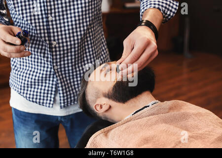 Professional barber working with client in hairdressing salon Stock Photo