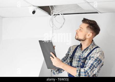 Electrician inspecting surveillance camera Stock Photo