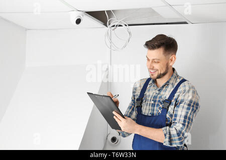 Electrician inspecting surveillance camera Stock Photo