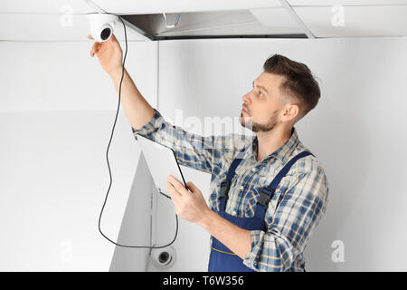Electrician inspecting surveillance camera Stock Photo