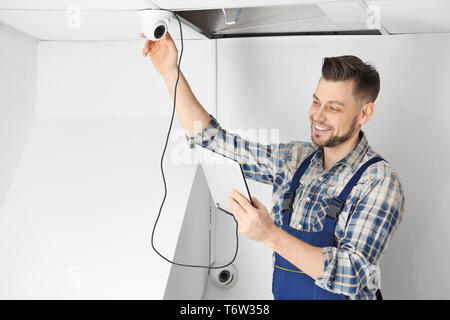 Electrician inspecting surveillance camera Stock Photo