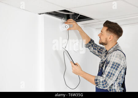 Electrician inspecting surveillance camera Stock Photo