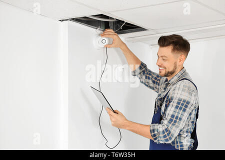 Electrician inspecting surveillance camera Stock Photo