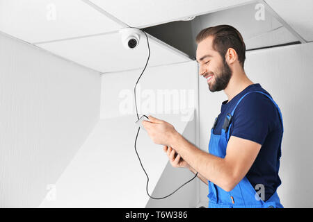 Electrician inspecting surveillance camera Stock Photo