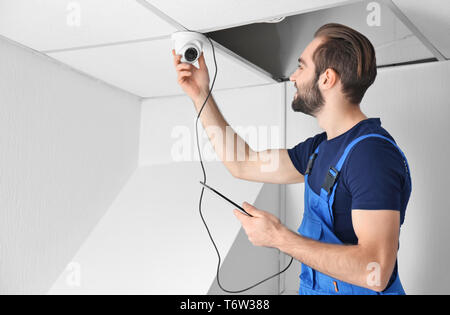 Electrician inspecting surveillance camera Stock Photo