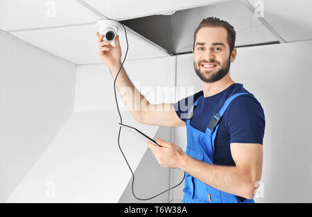 Electrician inspecting surveillance camera Stock Photo