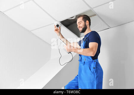 Electrician inspecting surveillance camera Stock Photo