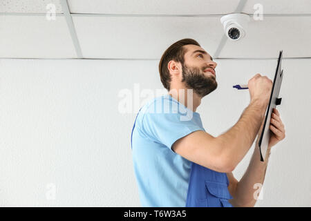 Electrician inspecting surveillance camera Stock Photo