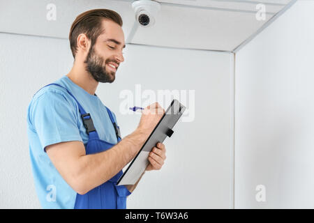 Electrician inspecting surveillance camera Stock Photo