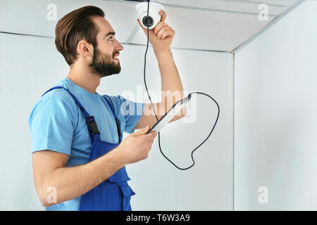 Electrician inspecting surveillance camera Stock Photo