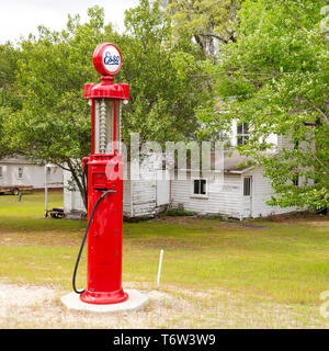 A vintage petrol pump in South Carolina, USA. The nozzle hangs from the red metal pump. Stock Photo