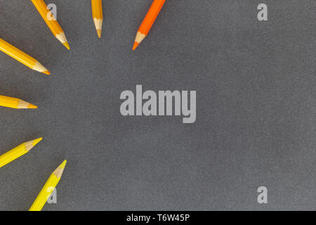 Colored pencils in semicircle close together on dark background Stock Photo