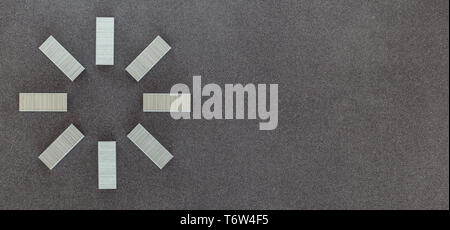 New metal staples for stapler top view on dark background Stock Photo